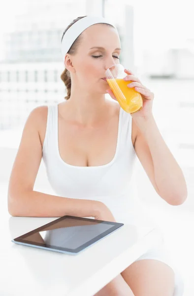 Peaceful pretty sportswoman drinking orange juice — Stock Photo, Image