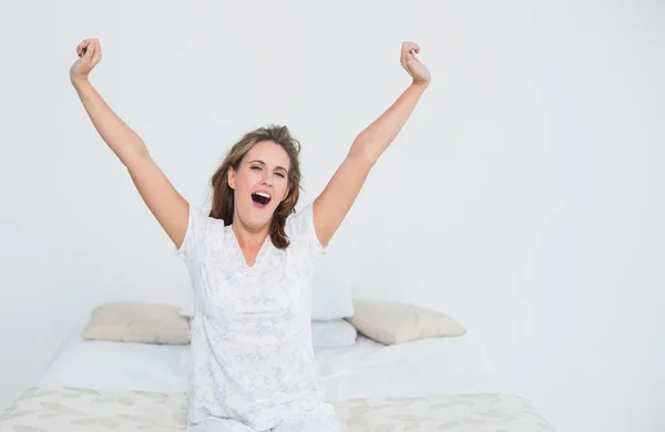 Hübsche Frau im Bett dehnt sich beim Aufwachen — Stockfoto