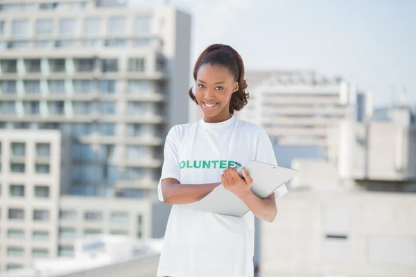 Femme bénévole souriante tenant presse-papiers — Photo