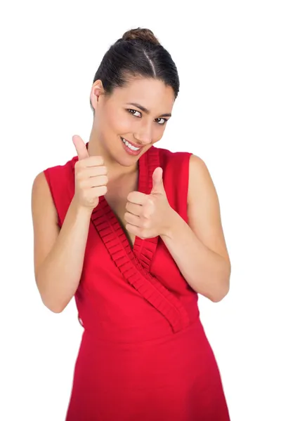 Cheerful sexy brunette in red dress thumbs up — Stock Photo, Image