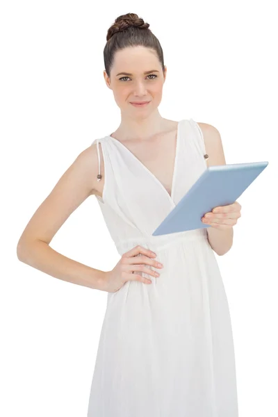 Молодая модель в белом платье держит планшетный компьютер — стоковое фото