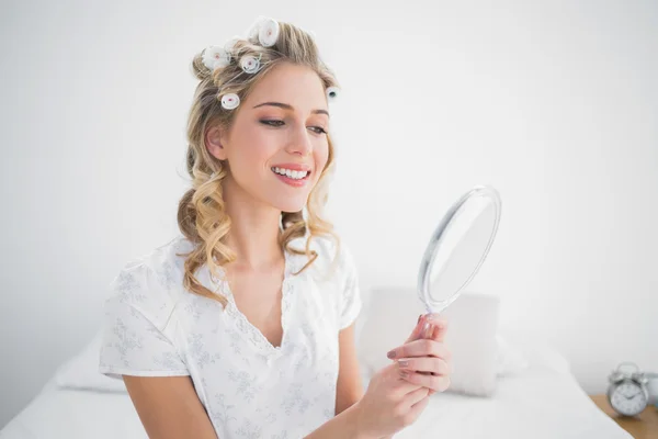 Gelukkig blonde kijken spiegelbeeld op gezellige bed — Stockfoto