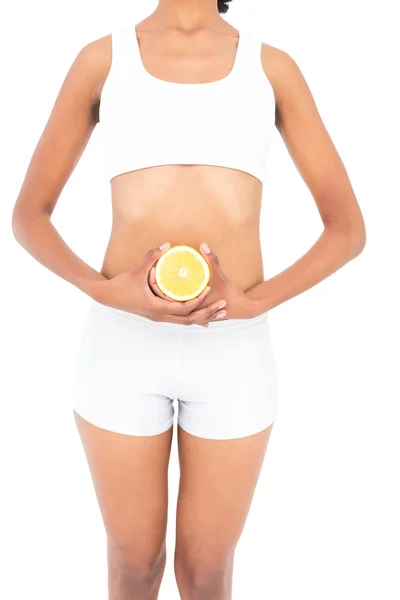 Close up of a fit model presenting half an orange — Stock Photo, Image