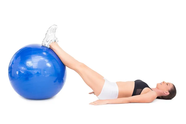 Visão lateral da mulher em forma deitada trabalhando com bola de exercício — Fotografia de Stock