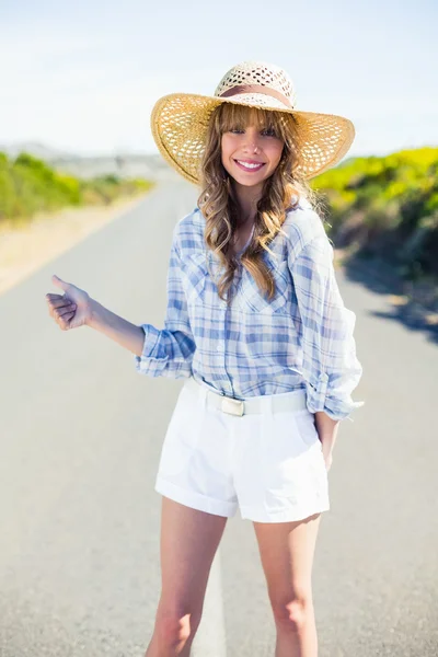 Cheerful gorgeous blonde hitchhiking on the road — Stock Photo, Image