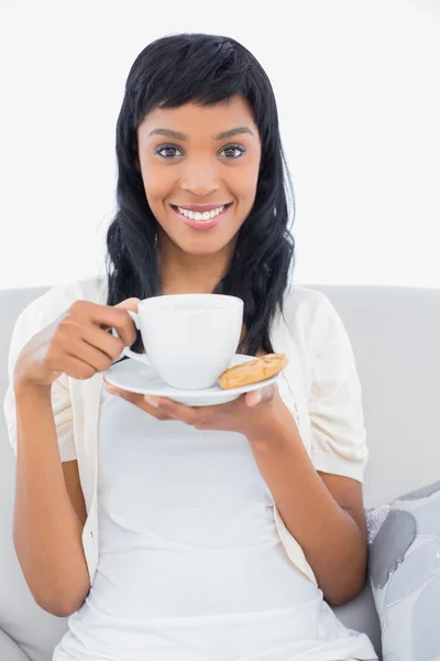 Pleased black haired woman in white clothes drinking coffee — Stock Photo, Image