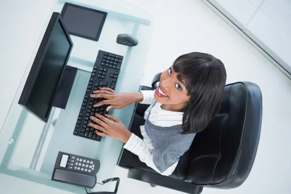 Overhead of smiling pretty businesswoman typing — Stock Photo, Image