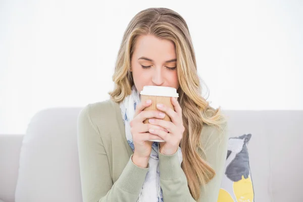 Relajado lindo rubia bebiendo café sentado en acogedor sofá —  Fotos de Stock