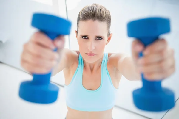 Serious woman exercising with dumbbells — Stock Photo, Image