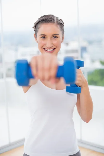 Fröhliche athletische Brünette, die mit Hanteln trainiert — Stockfoto