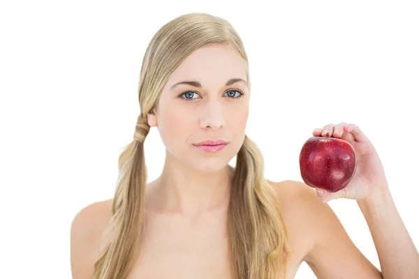 Kırmızı elma tutan ciddi sarışın kadın — Stok fotoğraf