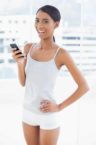 Happy sporty model using her smartphone — Stock Photo, Image