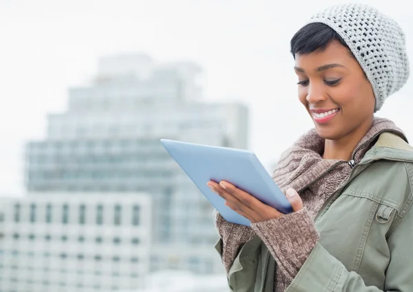 Natural young model in winter clothes using a tablet pc — Stock Photo, Image
