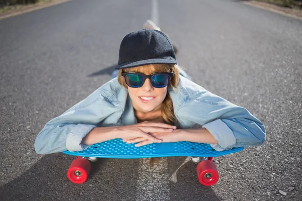 Funky young blonde lying on a deserted road — Stock Photo, Image