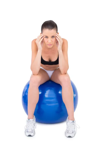 Egzersiz topu üzerinde oturup endişeli fit kadın — Stok fotoğraf