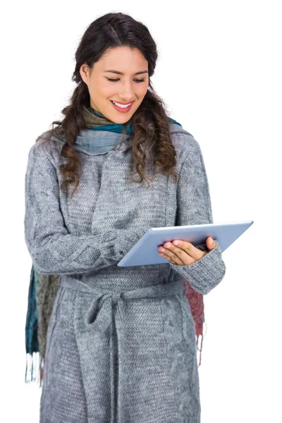 Morena relajada vistiendo ropa de invierno sosteniendo su tableta — Foto de Stock