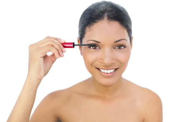 Allegro modello dai capelli neri che applica il mascara — Foto Stock