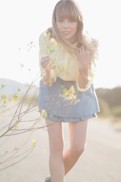 Hipster girl smelling flowers — Stock Photo, Image