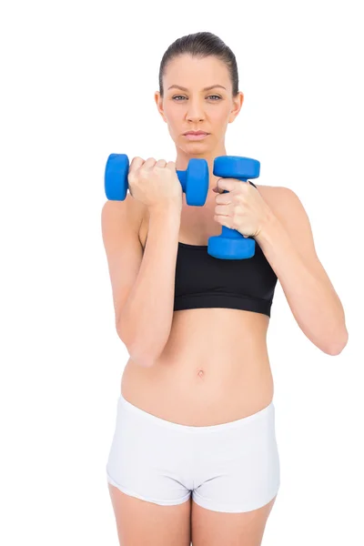 Serious sporty brunette working out with dumbbells — Stock Photo, Image