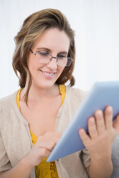 Lächelnde Frau mit Brille blickt auf Tablet-Bildschirm — Stockfoto