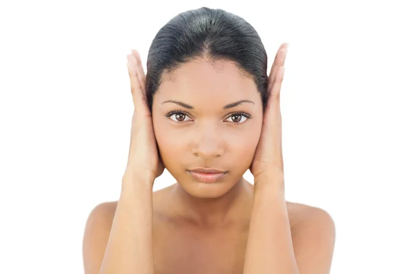 Serious black haired model blocking her ears — Stock Photo, Image