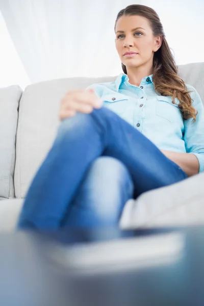 Femme sérieuse assise sur le canapé — Photo