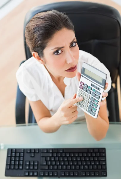 Seriöser Buchhalter, der einen Taschenrechner in die Kamera hält — Stockfoto