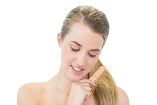 Veselá atraktivní blondýnka česání vlasy — Stock fotografie