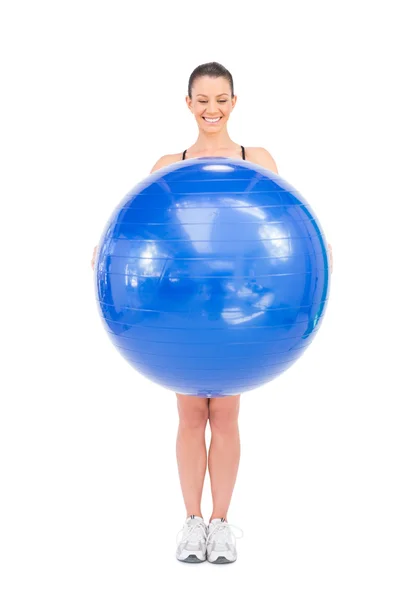 Happy fit woman holding exercise ball in front of her — Stock Photo, Image