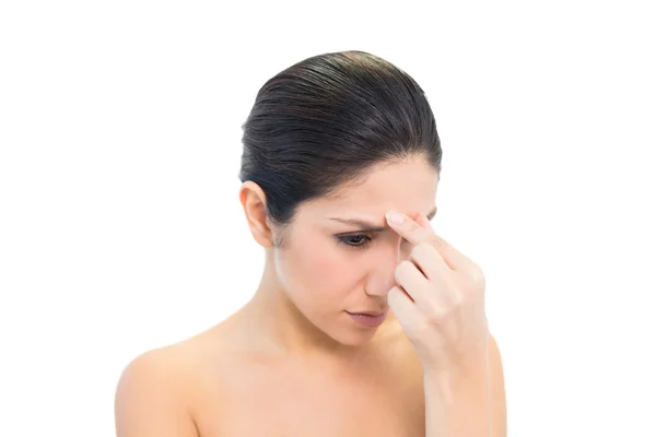 Frowning brunette with a headache pinching her nose — Stock Photo, Image