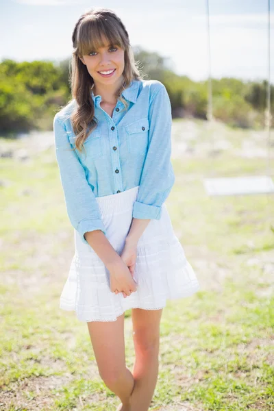 Smiling young woman posing next to a swing — Stock Photo, Image