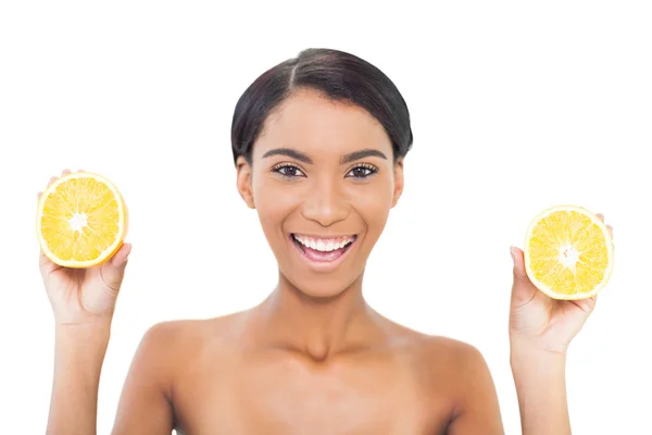 Modelo atraente alegre segurando fatias de laranja em ambas as mãos — Fotografia de Stock