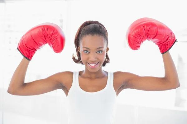 Mulher atlética magra usando luvas de boxe fazendo gesto vitorioso — Fotografia de Stock