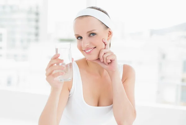 Fundersam ganska idrottskvinna håller ett glas vatten — Stockfoto