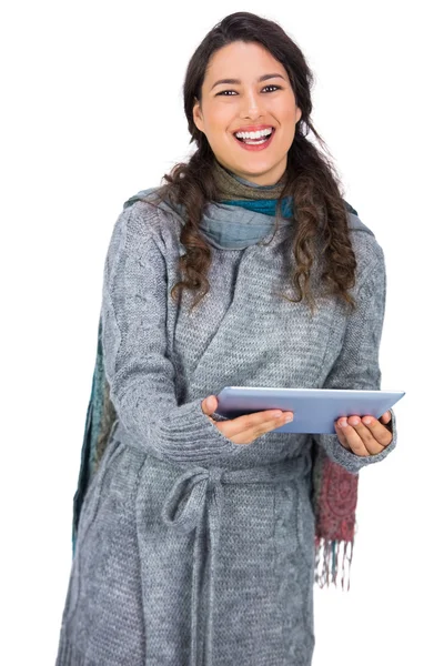 Feliz guapa morena vistiendo ropa de invierno sosteniendo su tablet — Foto de Stock