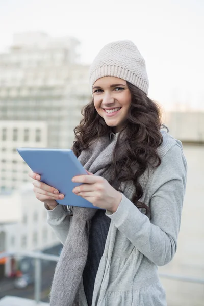 Uśmiechający się ładna brunetka, trzymając jej komputera typu tablet — Zdjęcie stockowe