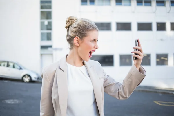 Angry stylish businesswoman shouting at her phone — Stock Photo, Image