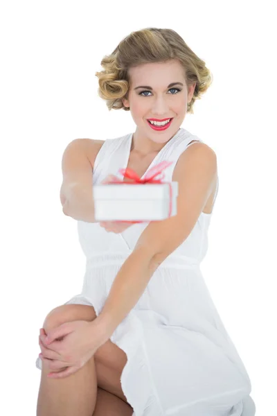 Sonriente modelo rubia de moda que ofrece un regalo — Foto de Stock