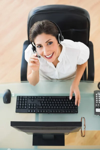 Fröhlicher Callcenter-Agent, der während eines Anrufs in die Kamera schaut — Stockfoto