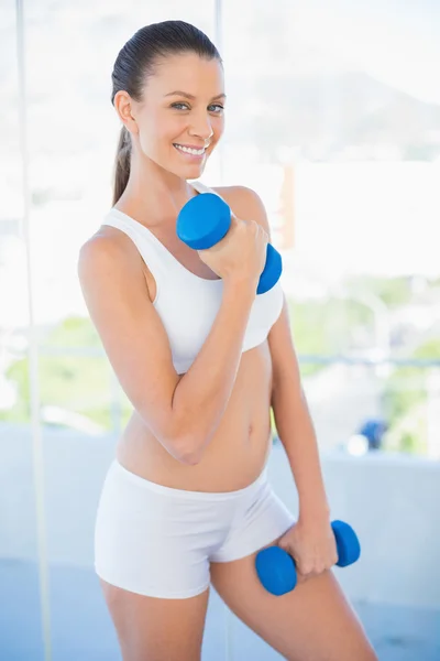 Happy woman lifting dumbbell — Stock Photo, Image