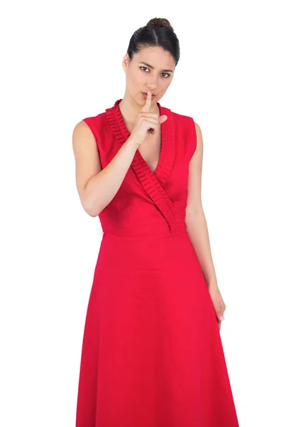 Modelo glamuroso en vestido rojo manteniendo en secreto —  Fotos de Stock