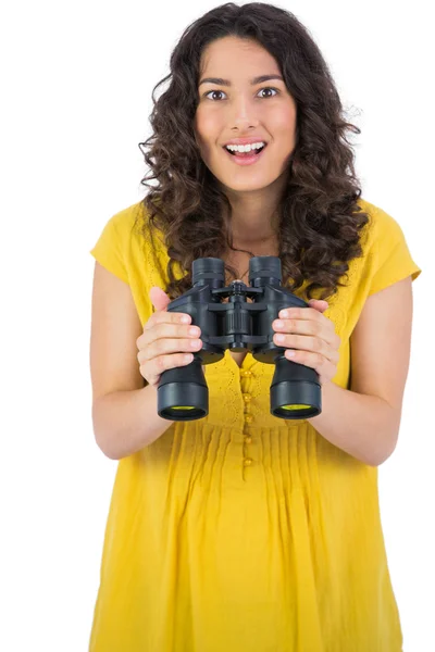 Sorridente casuale giovane donna in possesso di binocolo — Foto Stock