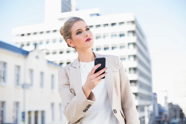 Pensive attractive businesswoman sending a text message — Stock Photo, Image