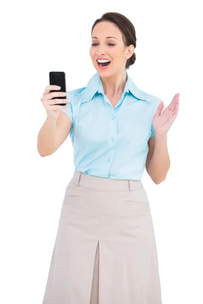 Cheerful classy businesswoman looking at her smartphone — Stock Photo, Image