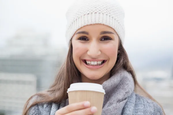 Glad brunett med vinterkläder på hålla mugg kaffe — Stockfoto