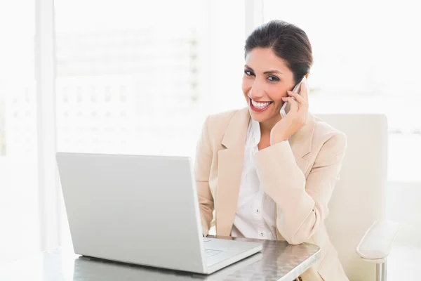 Mujer de negocios sonriente trabajando con un portátil en el teléfono —  Fotos de Stock