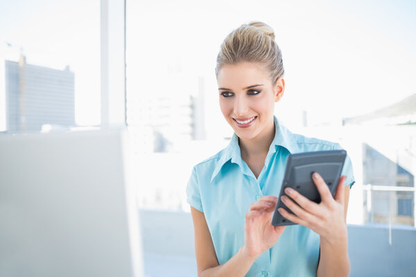 Happy elegant woman using calculator