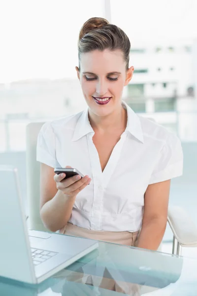 Donna d'affari sorridente guardando il suo smartphone — Foto Stock