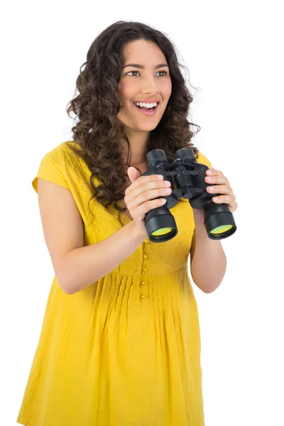 Cheerful casual young woman holding binoculars — Stock Photo, Image