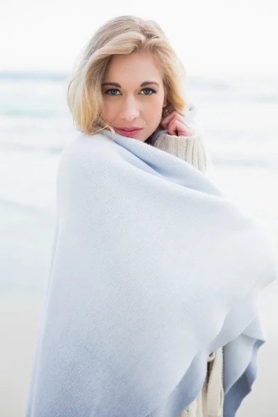 Friedliche blonde Frau, die sich in eine Decke hüllt — Stockfoto